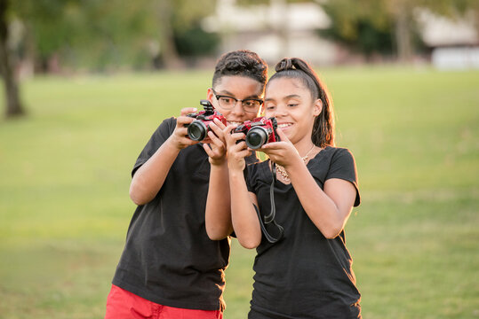 Twin brother and sister showing each other their photos