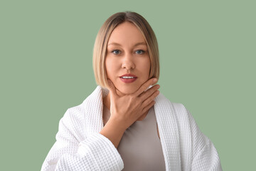 Woman doing face building exercise on green background