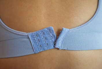 Bra attached to the female body from behind, conceptual photography