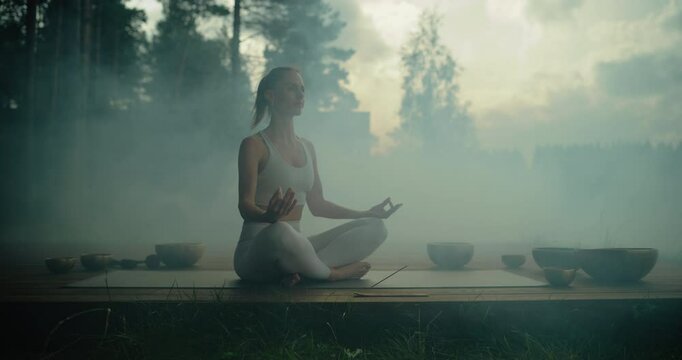 Female Yogi Performing a Spiritual Ritual with Smoke, Incenses and Singing Bowls, Cleansing Her Body and Soul, Doing Mindfulness Meditation and Breathing Exercises Outdoors in a Tranquil Forest