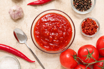 Glass bowl of chili sauce and different ingredients on white background