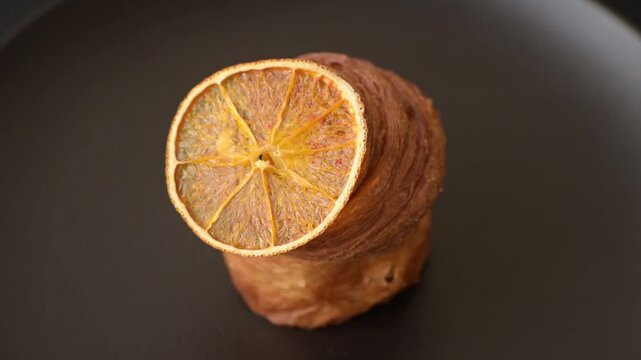 Sweet craffin made from puff pastry with Swiss meringue on a dark textured background
