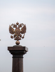 A metal eagle is perched on top of a stone pillar