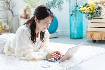 寝転びながら仕事をする若い女性