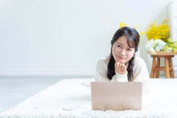 寝転びながら仕事をする若い女性