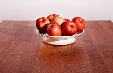 Red apples in white plate