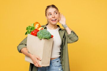 Young woman wear casual clothes hold bag for takeaway mock up with food products try to hear you...