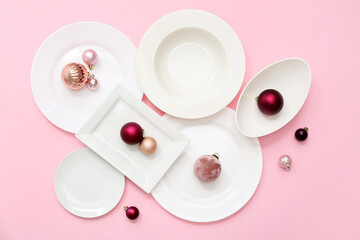 Beautiful table setting and Christmas balls on pink background