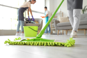 Female janitor mopping floor in room, closeup