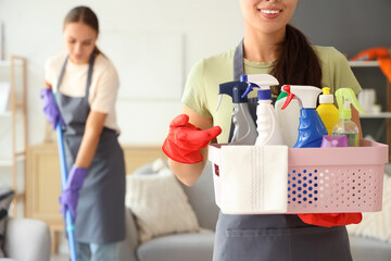 Female janitor with cleaning supplies in room, closeup