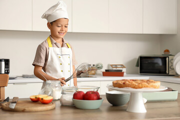 Cute little Asian chef cooking in kitchen