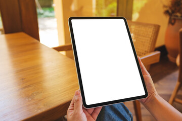 Mockup image of a woman holding digital tablet with blank desktop screen at home