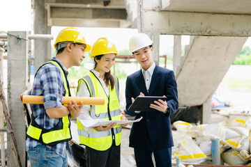 Contractor and architect looking at plan, tablet, laptop and talking about working on big project.