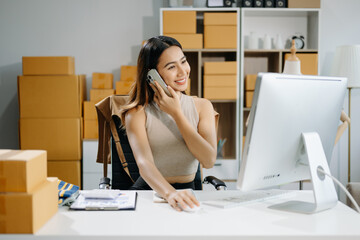 Young business owner woman prepare parcel box and standing check online orders for deliver