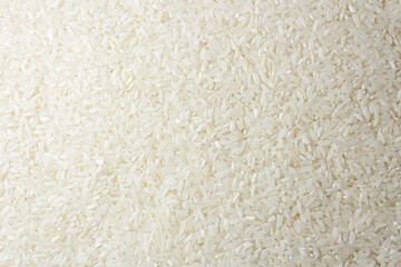 Dry Uncooked White Rice Background - Top View, Flat Lay. Scattered Raw Long Grain Rice. Asian Cuisine and Culture. Healthy Eating Ingredients. Diet Food