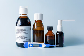 Seasonal diseases. Cold, runny nose, cough Medicines, spray and syrup, thermometer, pills, capsules on pastel background