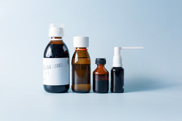 Seasonal diseases. Cold, runny nose, cough Medicines, spray and syrup, thermometer, pills, capsules on pastel background