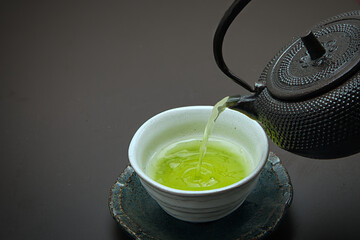 鉄でできた急須と茶碗に注がれた日本茶