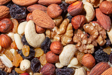 Mixed Nuts: Almonds, Walnuts, Cashews, Peanuts, Hazelnuts, Dried Prunes and Raisins. Different Nut Mix. Background from Various Nuts and Dried Fruits