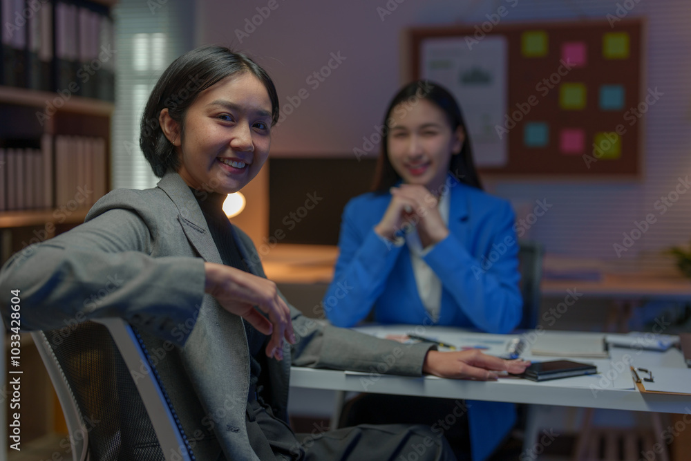 Wall mural two asian businesswomen come up with an idea. discuss investment projects and strategic planning wit