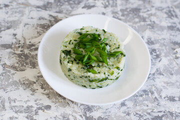 Vegan, vegetarian delicious dish. Rice with spinach on a white plate