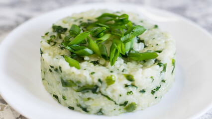 Vegan, vegetarian delicious dish. Rice with spinach on a white plate close-up. Concept of healthy eating