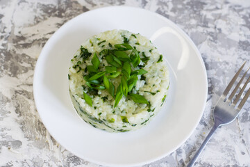 Vegan, vegetarian delicious dish. Rice with spinach on a white plate, flatlay. Concept of healthy eating