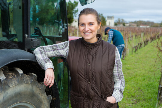 woman farmer posing next to a tractor