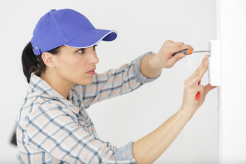 female engineer mounting electronic keypad to the wall