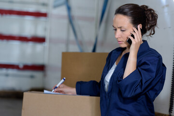 female warehouse worker checking delivering boxes