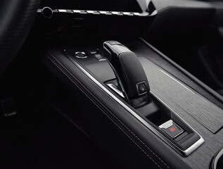 Automatic gear selector in luxury car. Automobile interior in dark tones, close-up view of bottom...