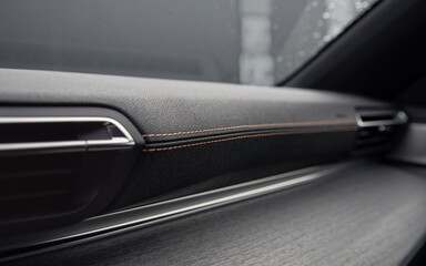 Leather trimmed front panel in a car. Interior of new automobile with stitched leather and wood trim.