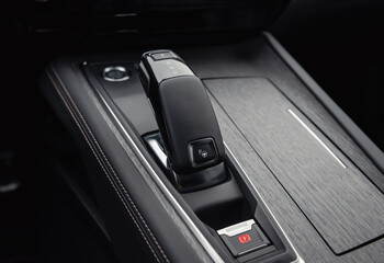 Automatic gear selector in luxury car. Automobile interior in dark tones, close-up view of bottom...