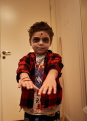 Sinister or scaring child pretends to be a zombie shot in the head as Halloween costume. Scary kid...