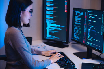 Asian woman  software development working on coding  computer screen and flowchart at night in...