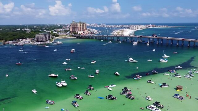 Cinematic Aerial View of Crab Island Off of Destin Florida. Crowd of people along with Vibrant fleet of yachts, pontoon boats adorn Crab Island, Florida's aerial view. Drone Shot of Crab Island Destin