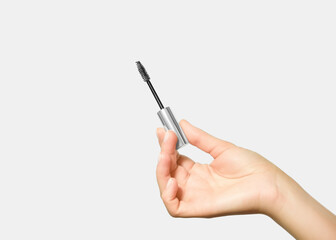 hand holding a brush with eyelash and eyebrow care serum