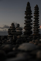 Stony Coast, high towers of stones in balance at shore of Black sea, bright light horizon, empty copy space. pebbles on coast, beach, standing tall. Batumi, Georgia.