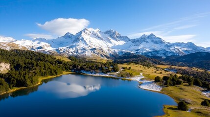 Obraz premium Majestic snow covered peaks of a towering mountain range reflected in the calm crystal waters of a scenic alpine lake a captivating natural landscape perfect for outdoor peaceful contemplation
