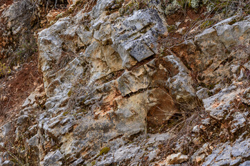 Natural rock formations with diverse textures and colors in a rugged landscape during daylight hours