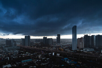 Dramatic dark blue sky before a storm comes over Bangkok in Thailand at night with street lights...