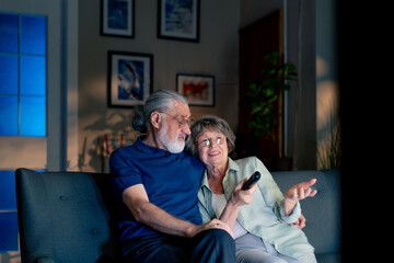 close up a bright living room with sofa grandma and grandpa watching tv switching channels leisure of elderly people happy couple