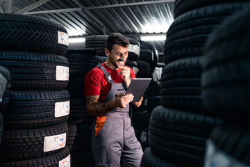 Storage worker checking tire status on his tablet computer.
