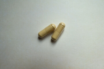 Group of two beige capsules of Saccharomyces boulardii probiotic dietary supplement