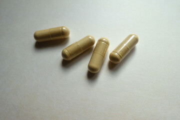 Closeup of four beige capsules of Saccharomyces boulardii probiotic dietary supplement