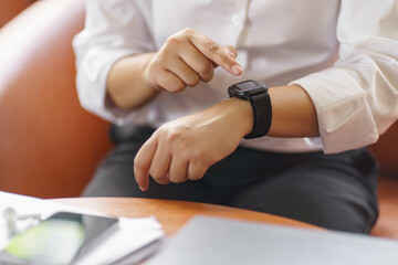 Business woman Looking at smart watch In Office online connect Gadget technology.