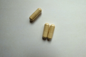 Close up of three beige capsules of Saccharomyces boulardii probiotic dietary supplement