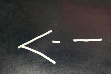 A simple drawing of the less than or equal to sign on a black board