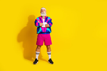 Full length photo of handsome confident senior guy oldschool sportswear arms crossed emtpy space isolated yellow color background