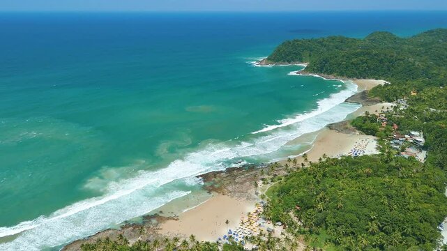 Drone descends over four sandy beaches, lush jungle, and blue ocean waves - Praia Tiririca, Praia do Resende, Itacare, Bahia, Brazil